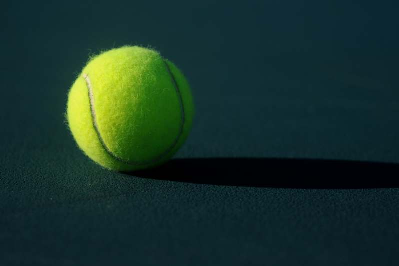 Close-up of hands gently squeezing a soft teal Breath Ball during a seated breathing exercise, natural light, minimalist background